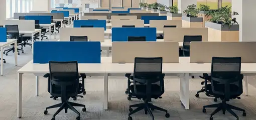 Modern open-plan office space featuring clean workstations, ergonomic chairs, and sanitized carpets provided by professional office cleaning services in New Orleans, LA.